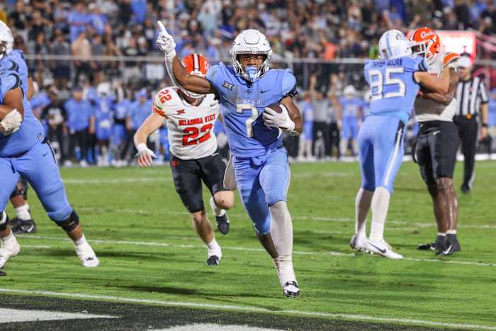 Nov 11, 2023; Orlando, Florida, USA; UCF Knights running back RJ Harvey (7) carries the ball for a touchdown during the second half against the Oklahoma State Cowboys at FBC Mortgage Stadium. 